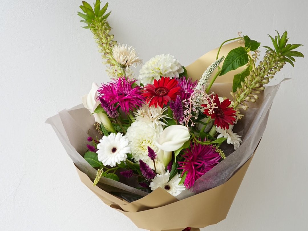 退職祝いにお作りした、赤やピンク、白の花を合わせた花束