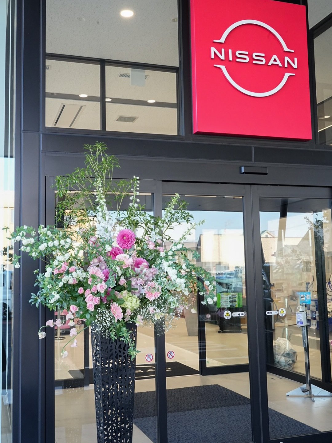 日産の看板の下の入口の装花